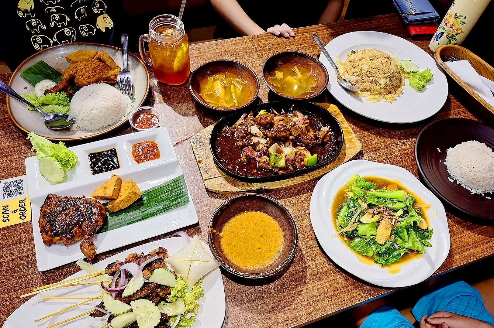 Yassin Kampung Seafood Singapore meal spread with sambal chicken, grilled skewers, fried rice, vegetables and sauces