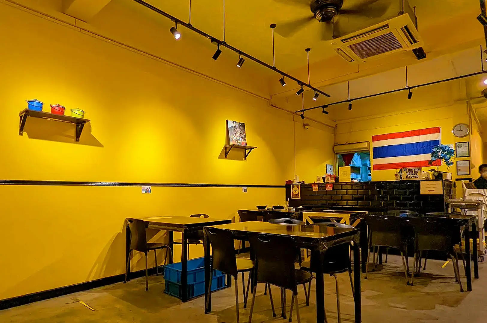 Pattaya Garden Restaurant dining area with yellow walls, tables, chairs and Thai-inspired interior décor