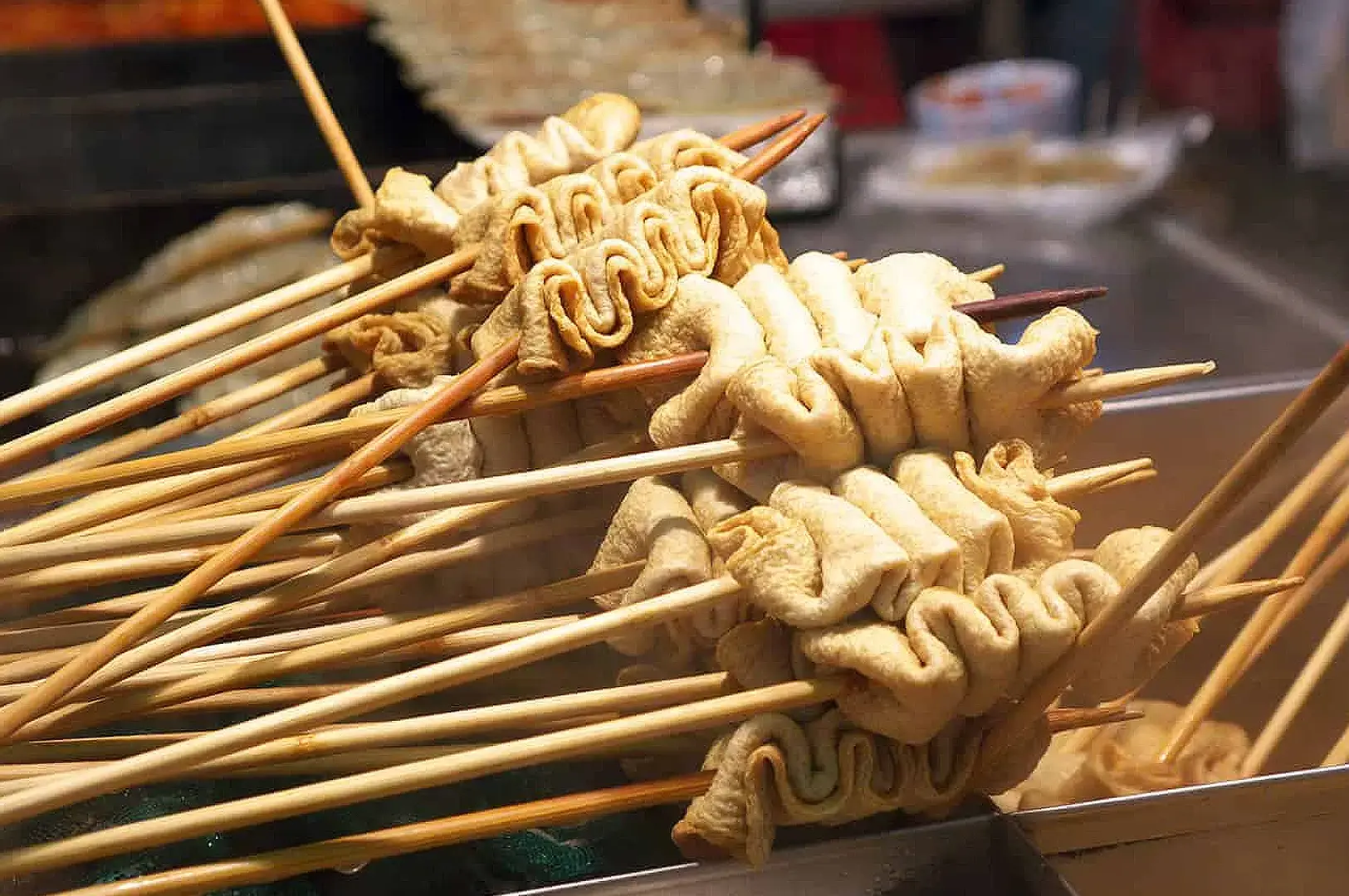 Korean fish cake skewers and street food served on wooden sticks at a Korean food stall