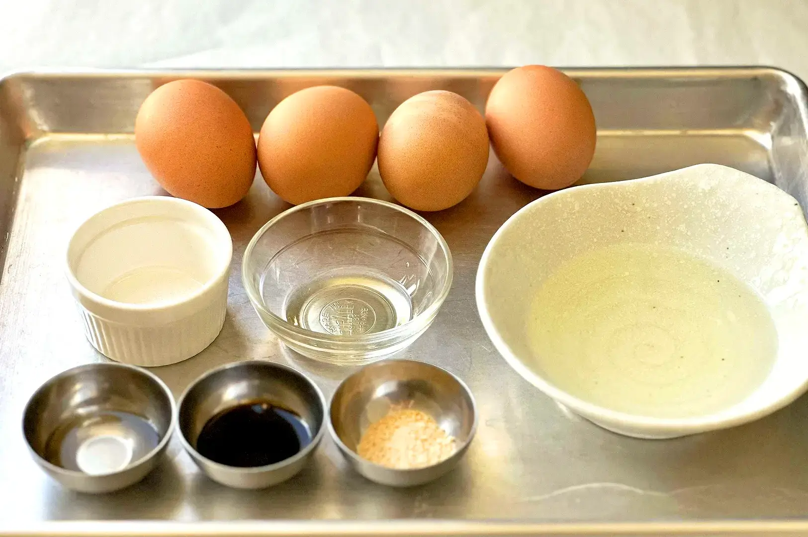 Dashimaki tamago ingredients including eggs, dashi, soy sauce and seasonings prepared for a Japanese rolled omelette