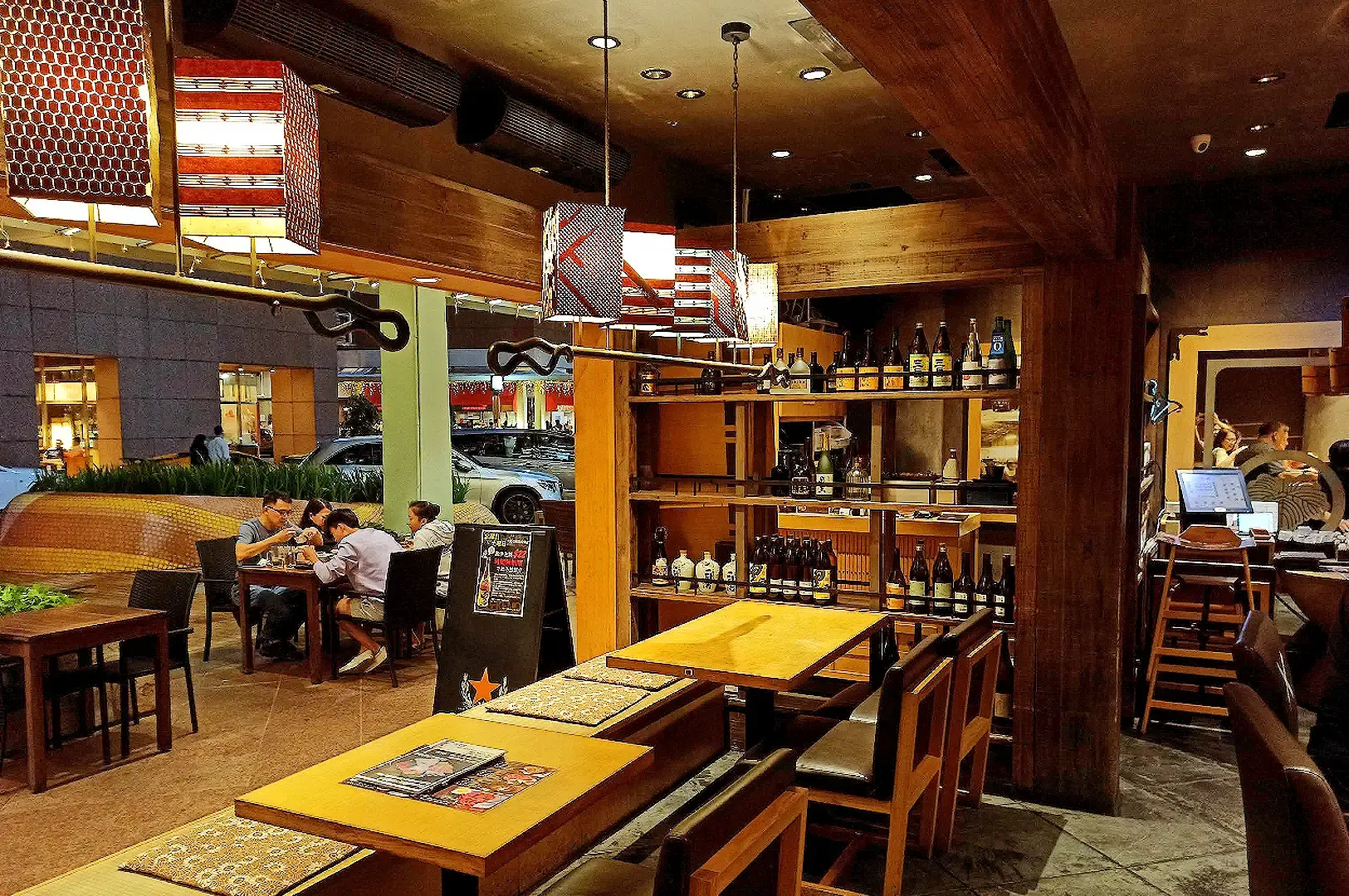Sandaime Bunji Japanese restaurant interior at Millenia Walk with warm wood furnishings, sake shelves and dining tables