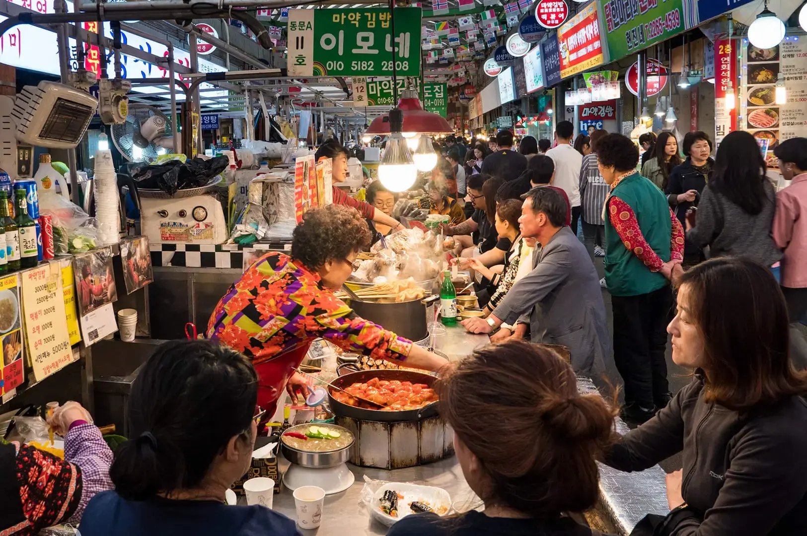 Busy Korean street food market with vendors serving traditional snacks and hot dishes