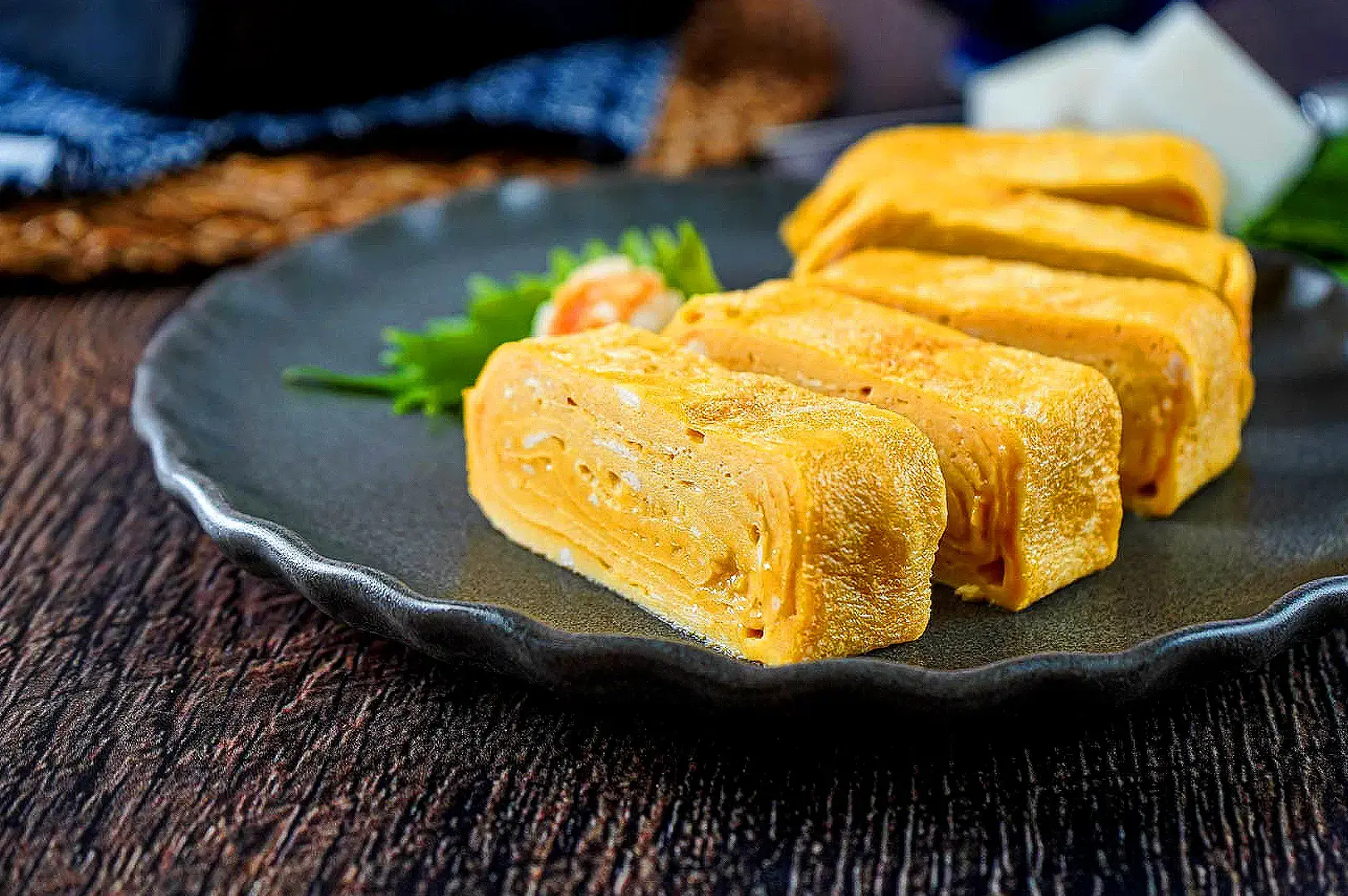 Japanese dashimaki tamago rolled omelette with soft layers and golden egg texture on a ceramic plate