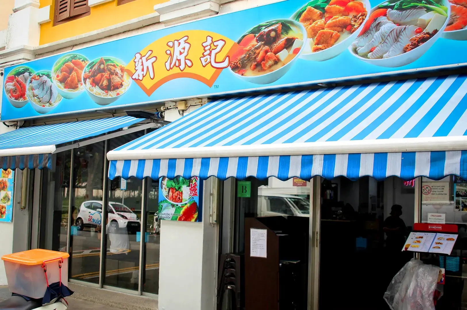 Xin Yuan Ji Fish Soup Singapore storefront with blue and white striped awning and seafood soup signage