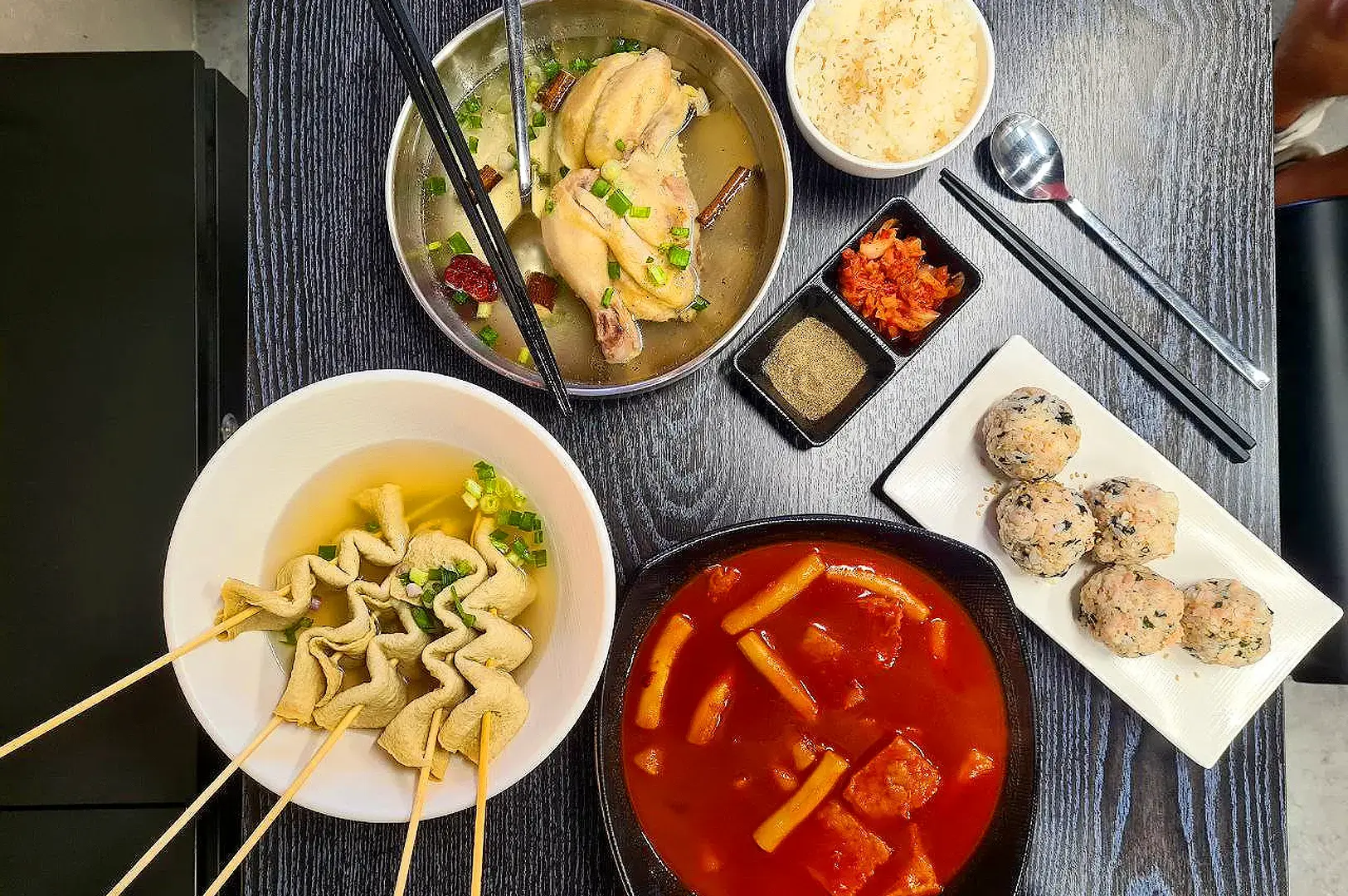 Meokja by Jungga Singapore Korean meal spread with chicken soup, tteokbokki, fish cakes and rice balls