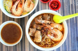 Prawn mee in Singapore with large prawns, pork ribs, noodles, bean sprouts and rich prawn broth