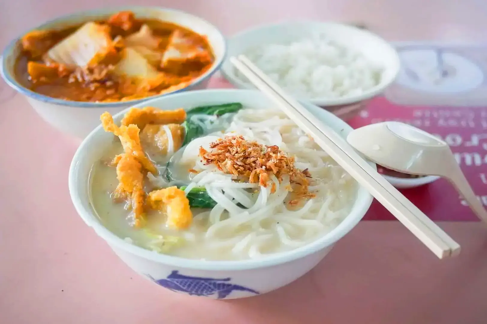 Singapore fish bee hoon soup with sliced fish, prawns, vegetables and crispy fried shallots